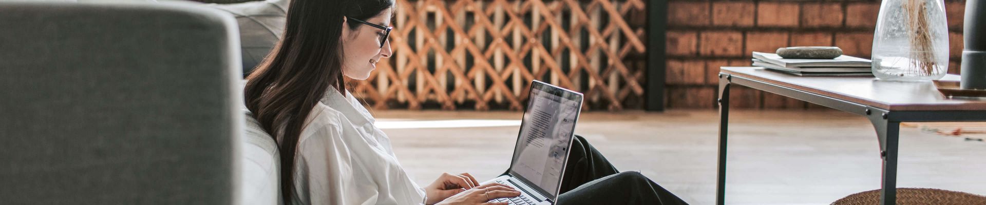 Lächelnde junge Frau vor ihrem Laptop