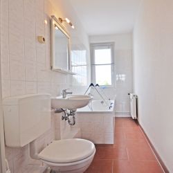 Tiled bathroom with bathtub and window