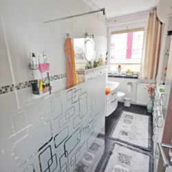 Gemütlich eingerichtetes Badezimmer mit großer Dusche und Fenster